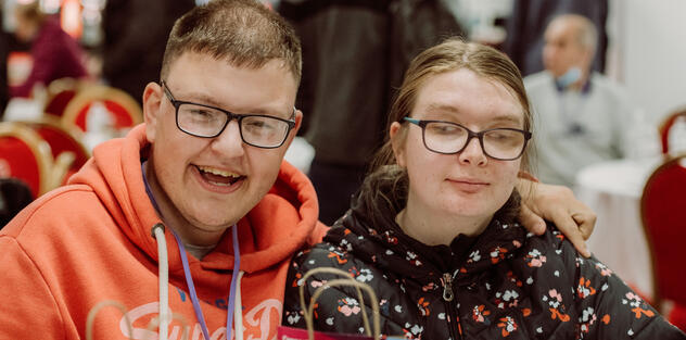 A young man and woman sitting at a table smiling